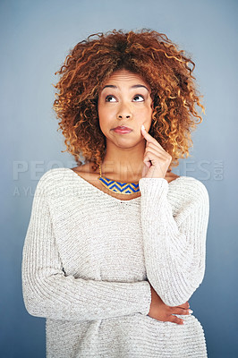 Buy stock photo Studio shot of an attractive young woman looking thoughtful against a grey background