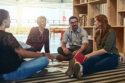 Buy stock photo Cropped shot of a group of business colleagues in the office sitting on the floor and discussing ideas