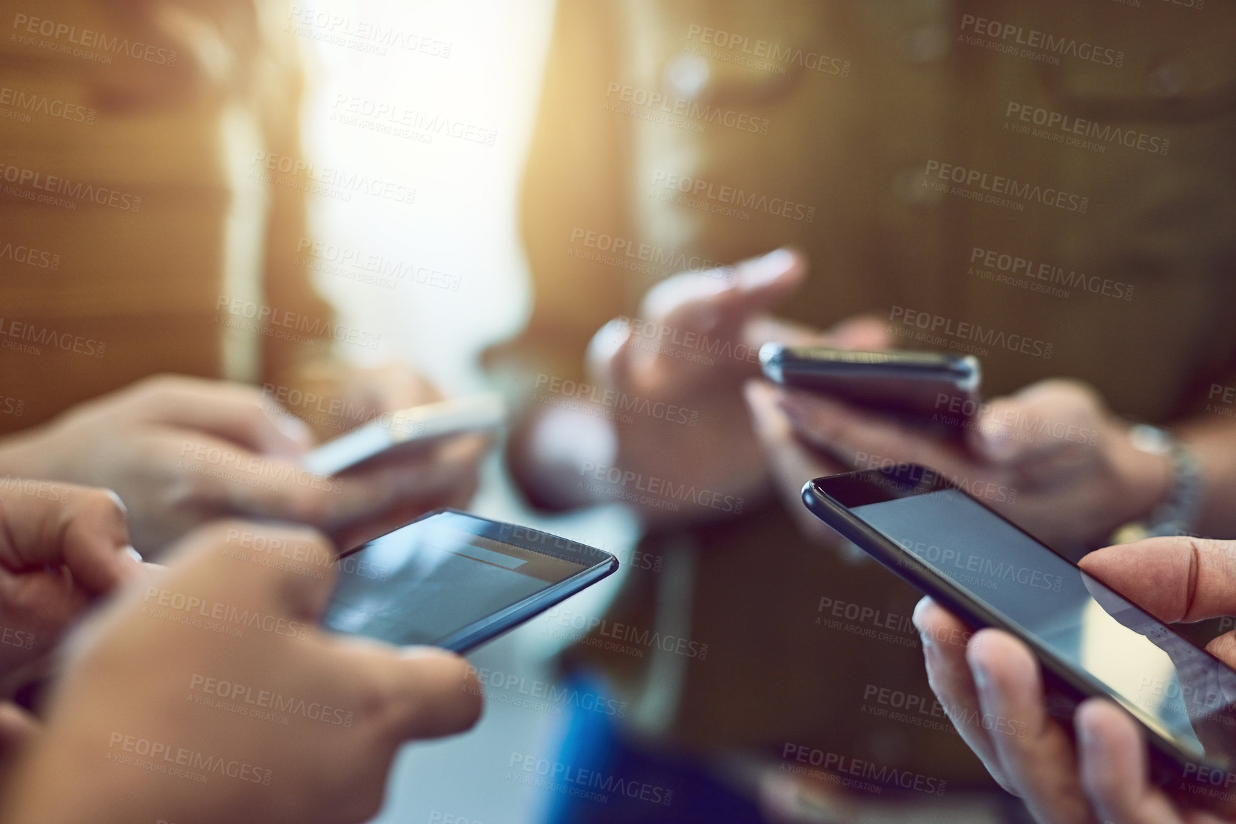 Buy stock photo Cropped shot of a group of colleagues using their smart phones in synchronicity