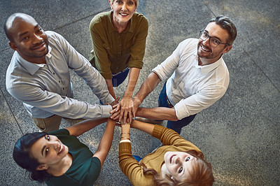 Buy stock photo High angle portrait of a group of colleagues joining their hands in solidarity at work