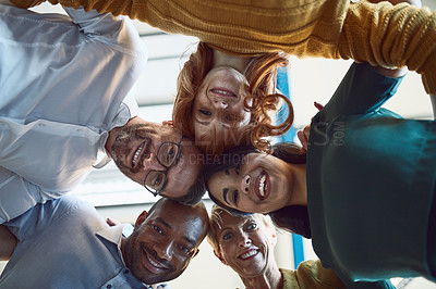 Buy stock photo Low angle shot of a group of colleagues huddled together in solidarity at work