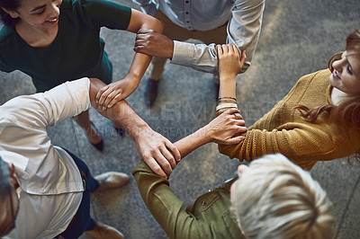Buy stock photo High angle shot of a group of colleagues linking arms in solidarity at work