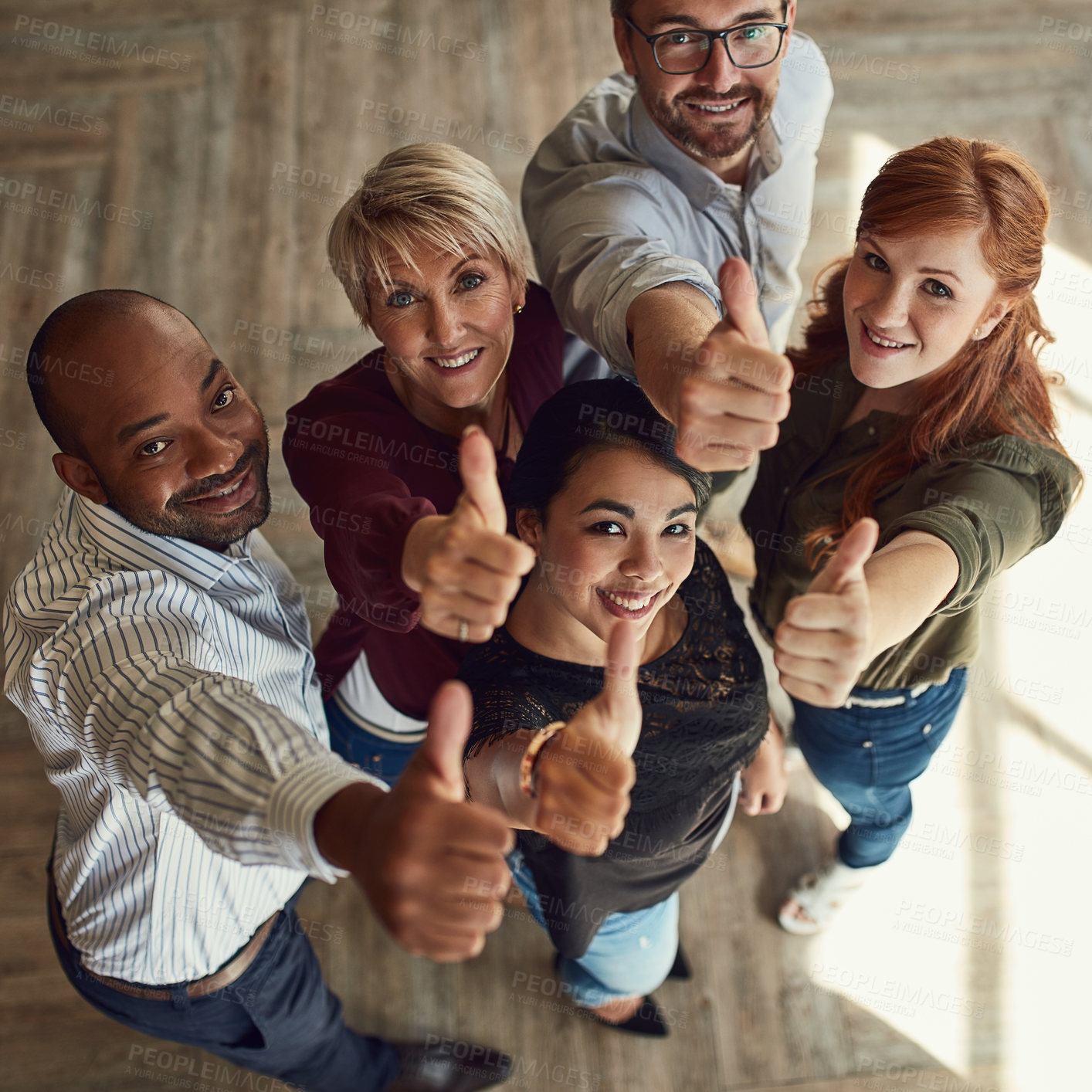 Buy stock photo High angle portrait of a team of colleagues giving a thumbs up in a modern office