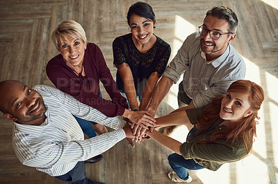 Buy stock photo High angle portrait of a group of colleagues joining their hands in solidarity at work