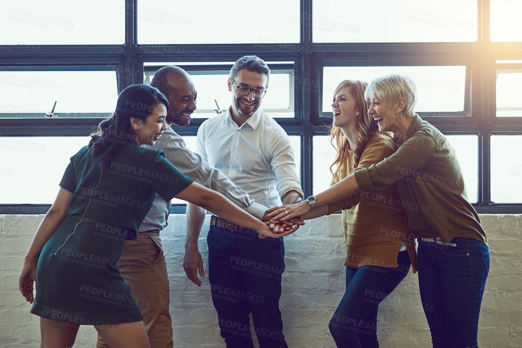 Buy stock photo Shot of a group of colleagues joining their hands in solidarity at work