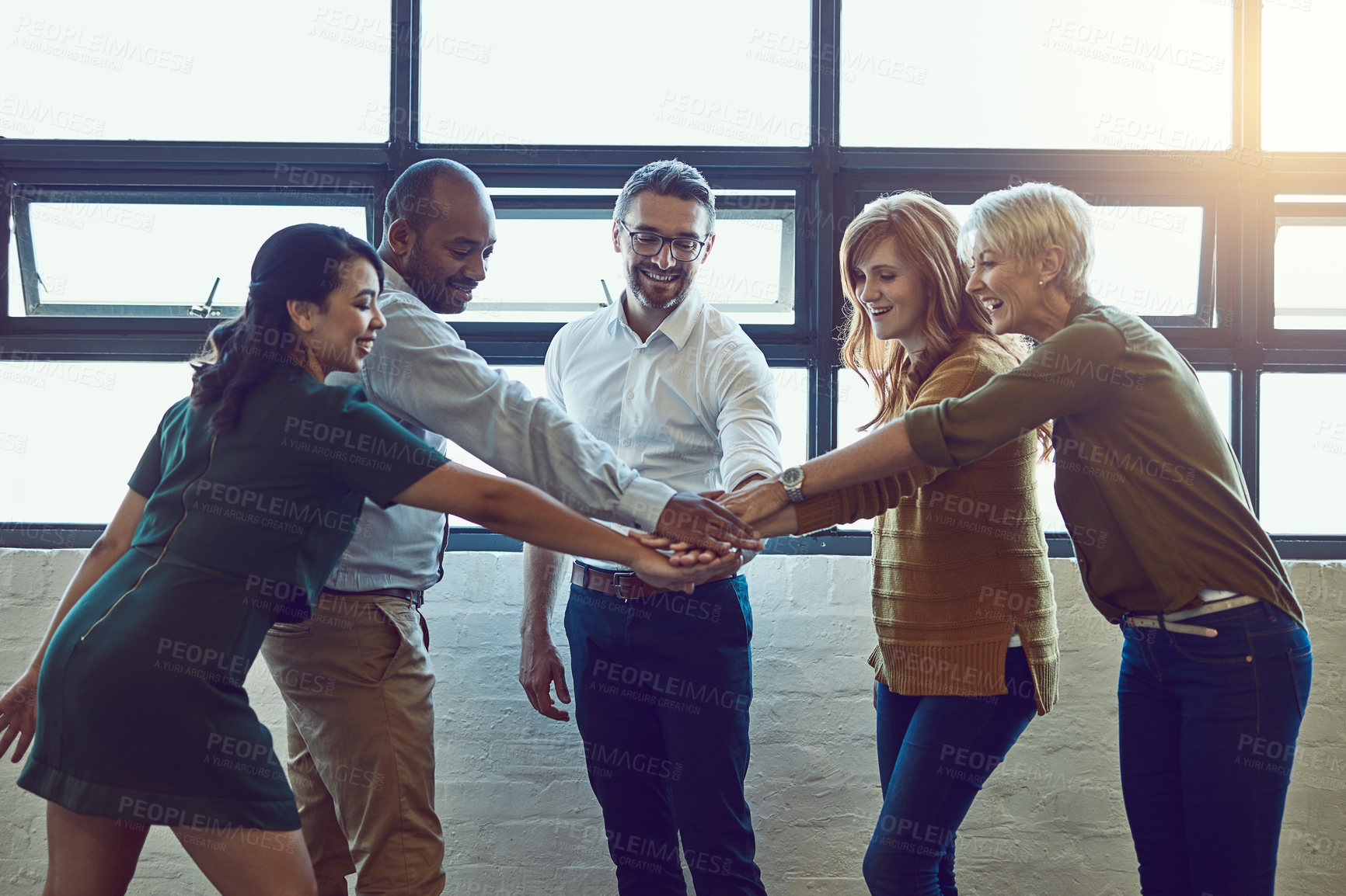 Buy stock photo Shot of a group of colleagues joining their hands in solidarity at work