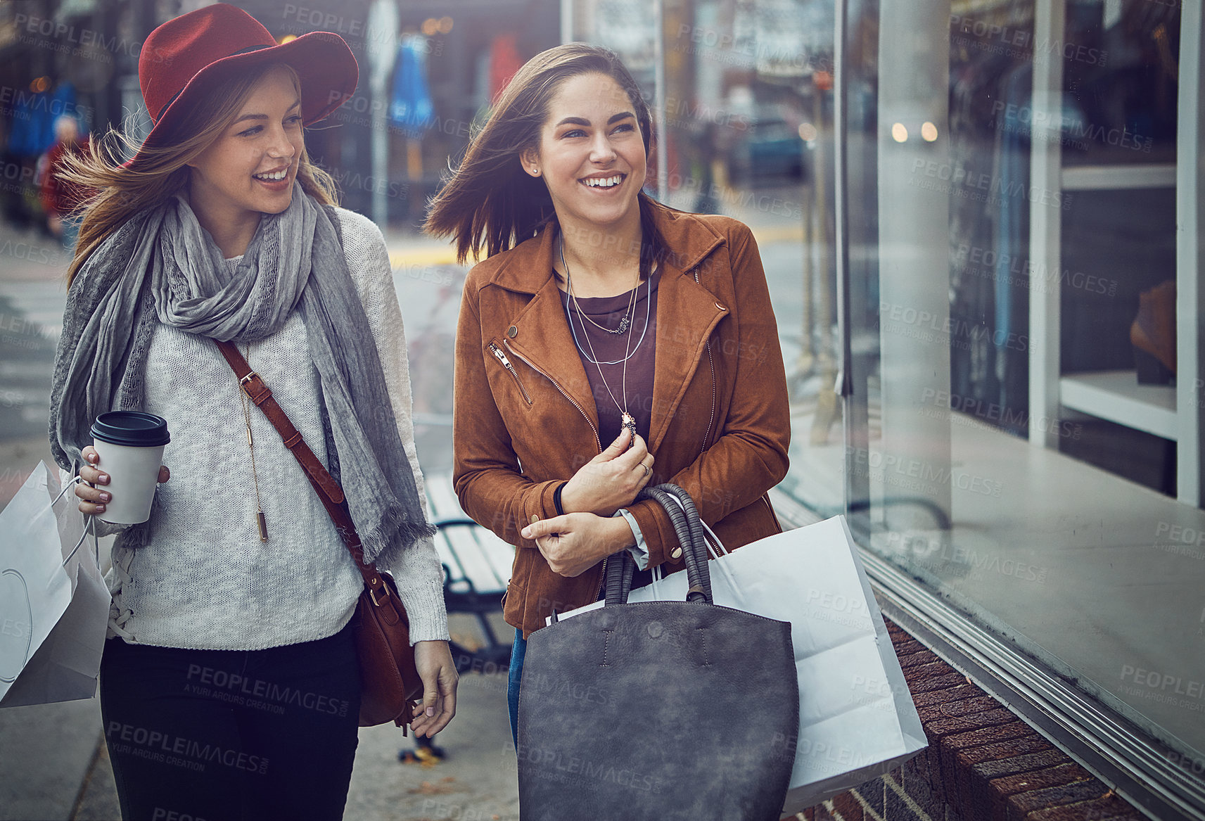 Buy stock photo Cropped shot of two young girlfriends walking around downtown while on a shopping spree