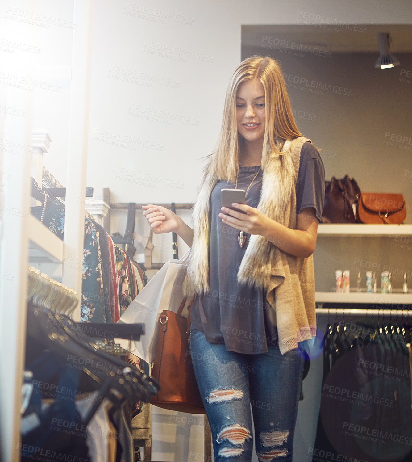 Buy stock photo Shot of a young woman using her cellphone while out shopping