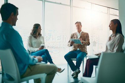 Buy stock photo Shot of a group of businesspeople taking notes while attending a meeting in the office