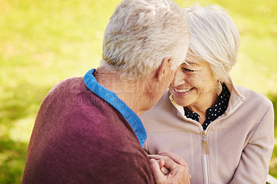 Buy stock photo Shot of a happy senior couple sharing a tender moment in the park