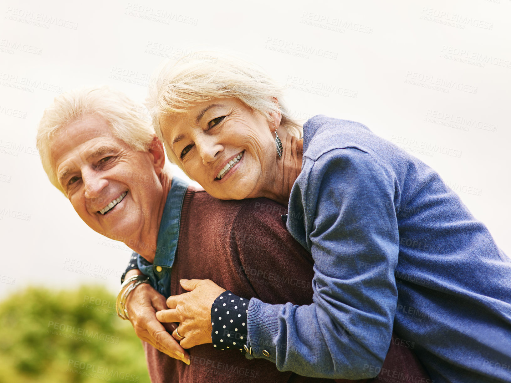 Buy stock photo Portrait of a happy senior couple enjoying a piggyback ride outdoors