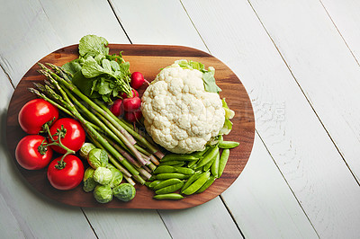 Buy stock photo Shot of a variety of fresh produce on a wooden chopping board