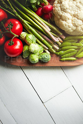 Buy stock photo Shot of a variety of fresh produce on a wooden chopping board