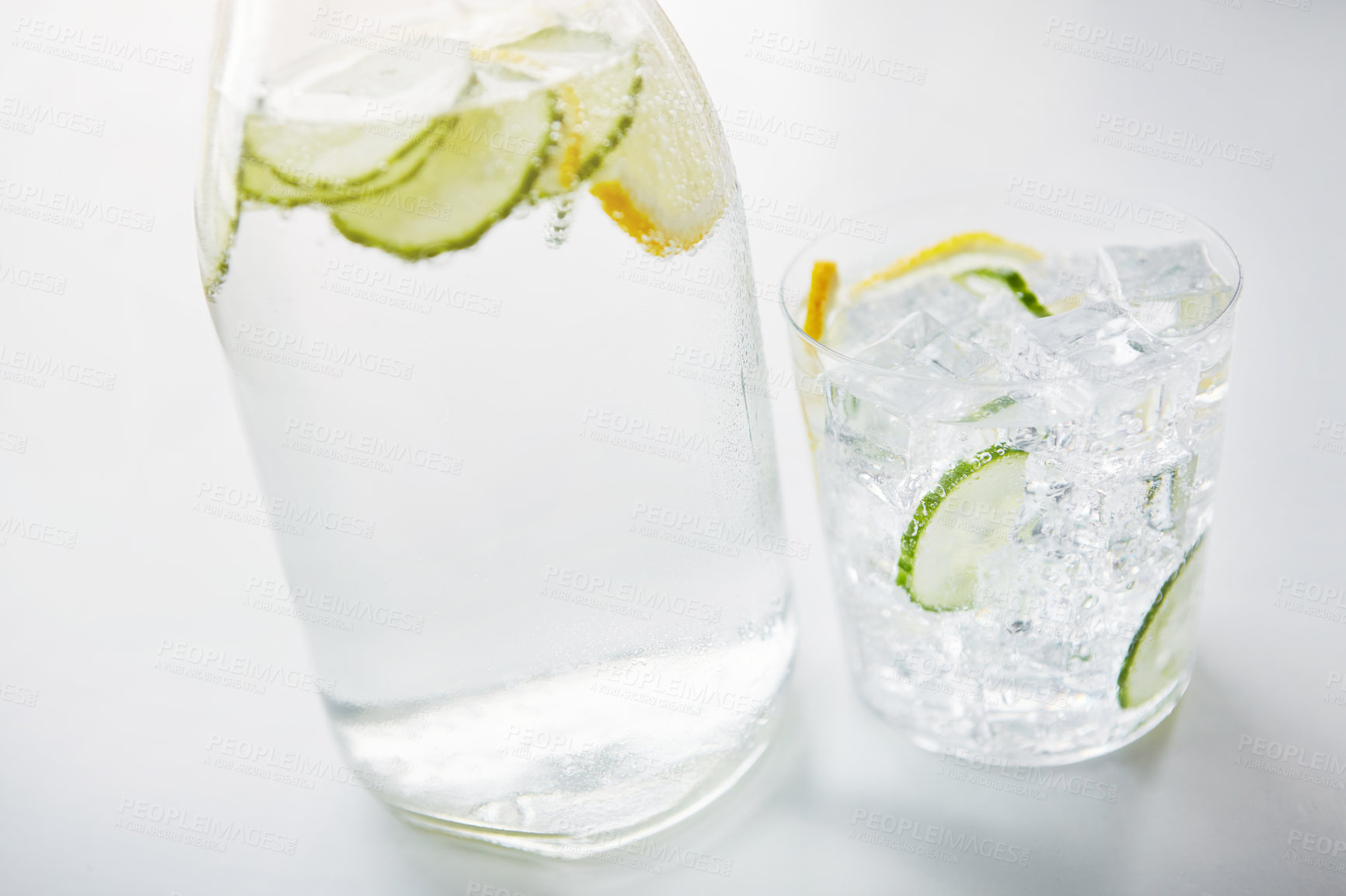 Buy stock photo Shot of a jug and glass of water with slices of lemon and cucumber in