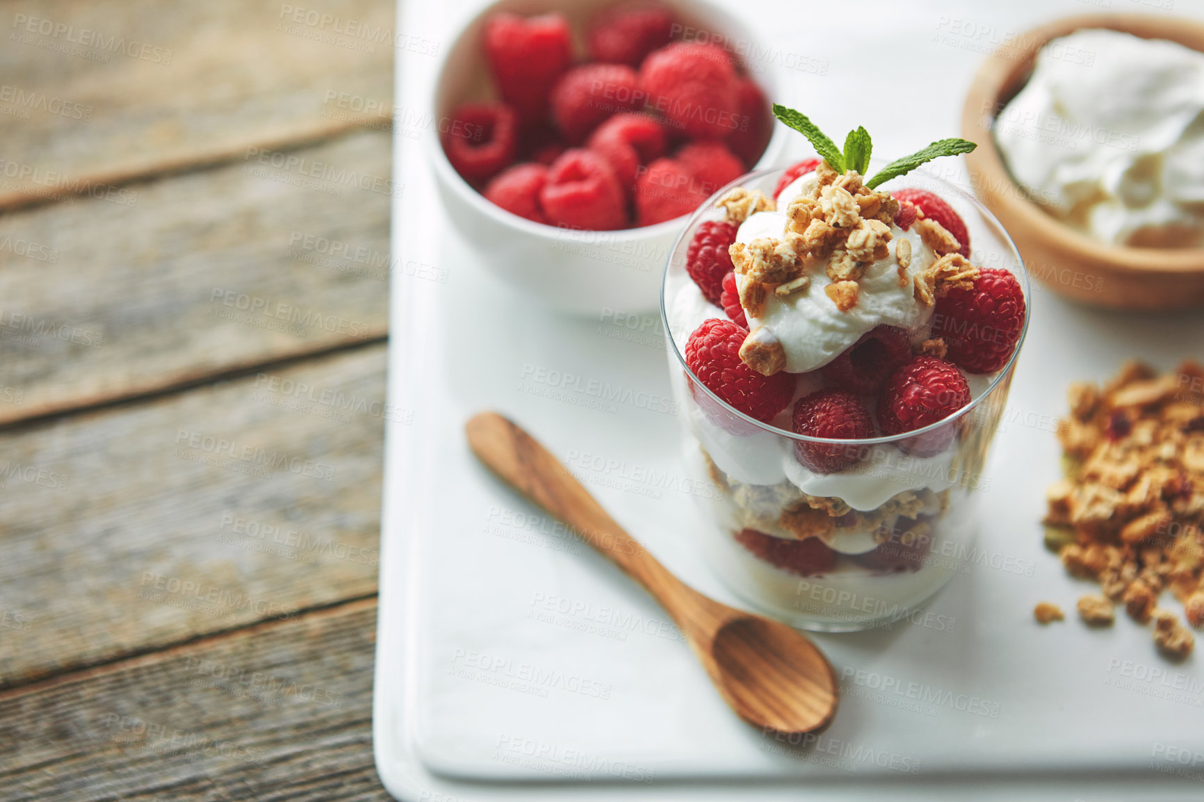 Buy stock photo Shot of of granola, yoghurt and berries in a glass and on a plate