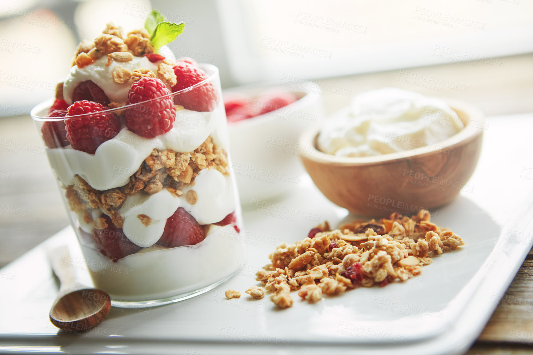 Buy stock photo Shot of of granola, yoghurt and berries in a glass and on a plate