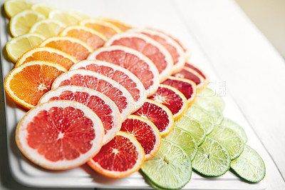 Buy stock photo Shot of a variety of citrus fruits cut into slices on a plate