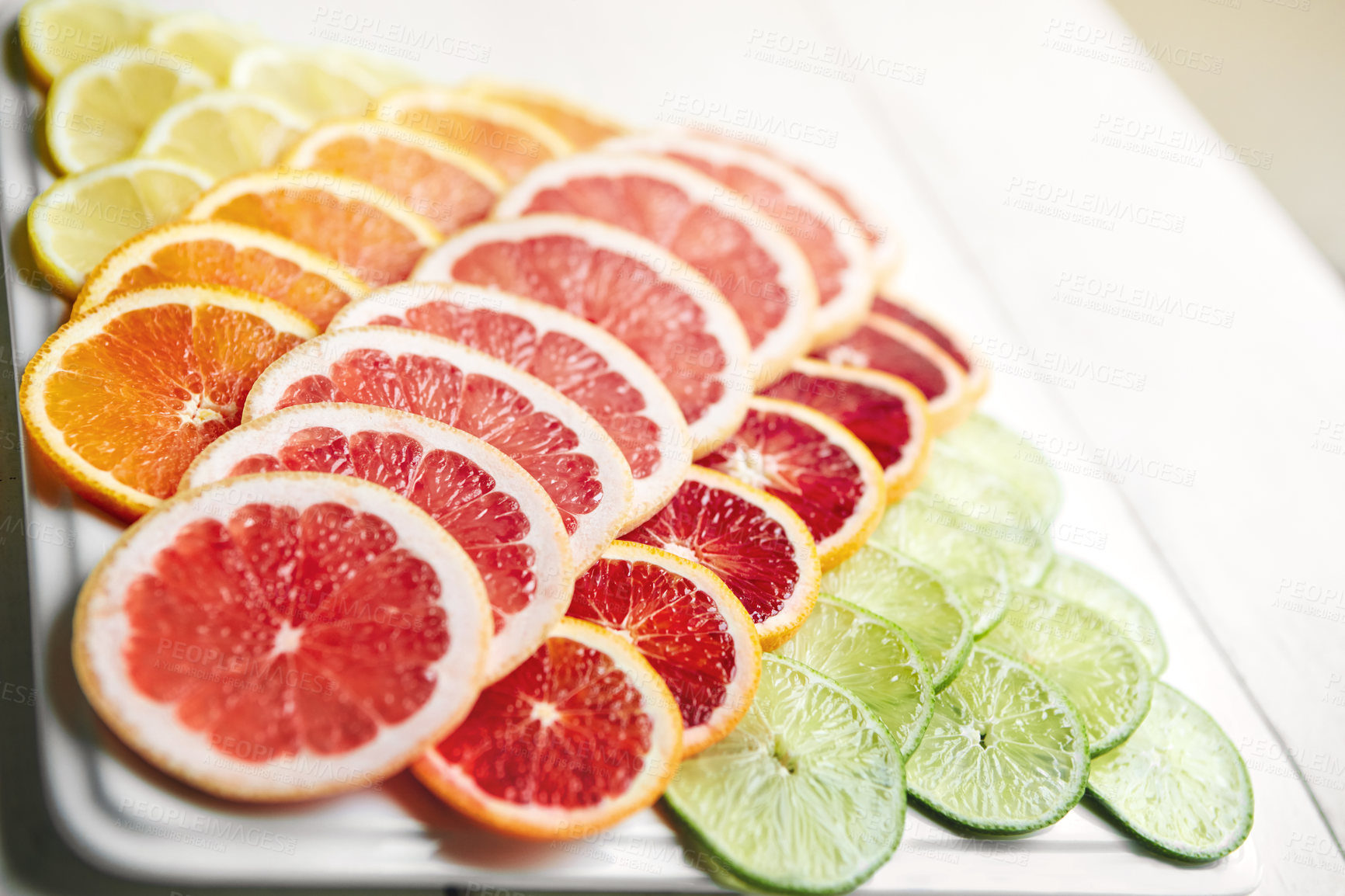 Buy stock photo Shot of a variety of citrus fruits cut into slices on a plate