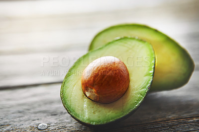 Buy stock photo Shot of a sliced avocado on a table