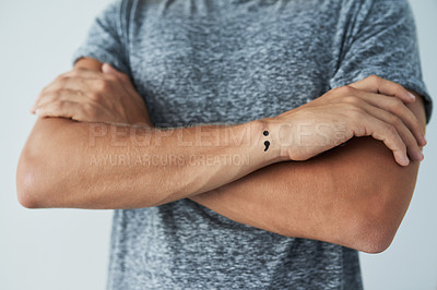 Buy stock photo Arms crossed, mental health and semicolon tattoo with person closeup in studio for awareness. Hope, perseverance or resilience and confident model on gray background with symbol on wrist of arm