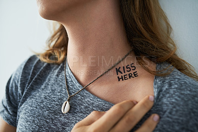 Buy stock photo Person, text or tattoo design on neck for unique creative style in studio on blue background. Identity, necklace or kiss here words with ink on skin for creativity, closeup or artistic expression