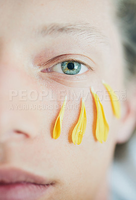Buy stock photo Cropped shot of a young man's face with flower petals under his eye while looking at the camera