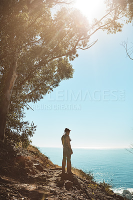 Buy stock photo Rear view shot of a young woman admiring the view from the top of a mountain