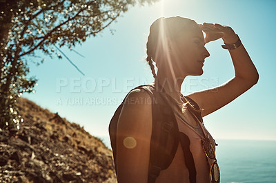 Buy stock photo Shot of a young woman admiring the view from the top of a mountain