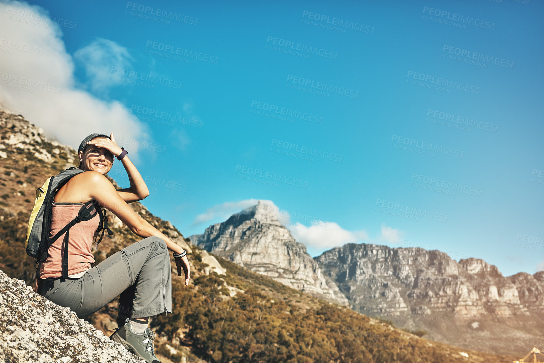 Buy stock photo Shot of a young woman taking a break while out on a hike through the mountains