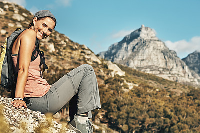 Buy stock photo Portrait of a young woman taking a break while out on a hike through the mountains