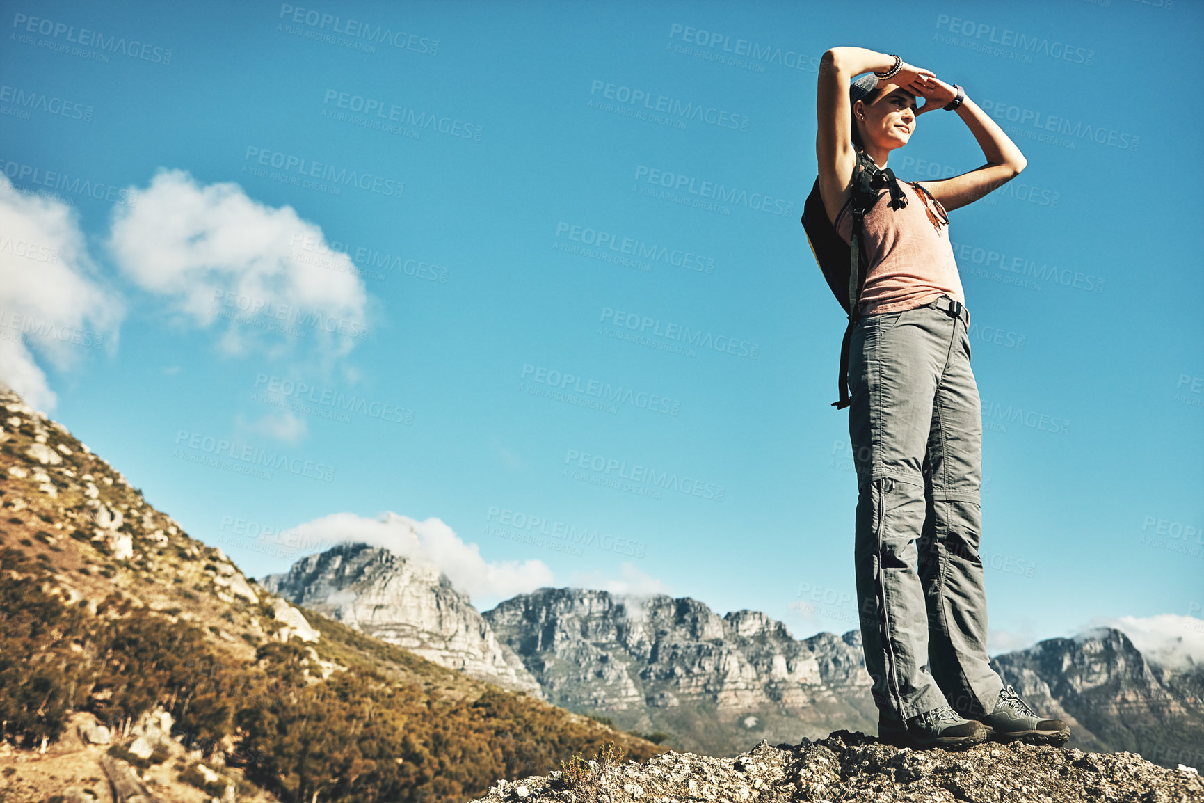 Buy stock photo Shot of a young woman admiring the view while out on a hike through the mountains
