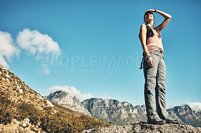 Buy stock photo Shot of a young woman admiring the view while out on a hike through the mountains