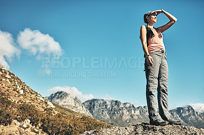 Buy stock photo Shot of a young woman admiring the view while out on a hike through the mountains