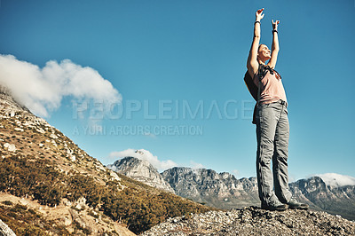 Buy stock photo Shot of a young woman celebrating while out on a hike through the mountains