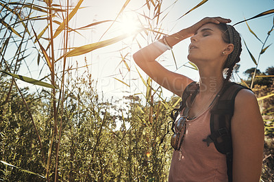 Buy stock photo Shot of a young woman looking exhausted while out on a hike