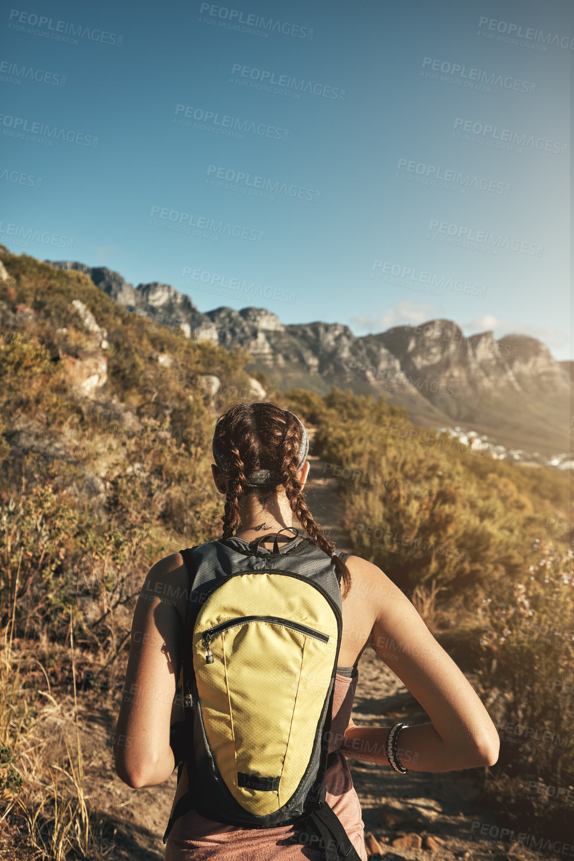 Buy stock photo Rear view shot of a young woman out on a hike through the mountains