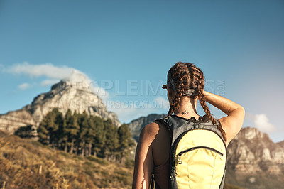 Buy stock photo Rear view shot of a young woman out on a hike through the mountains