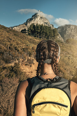 Buy stock photo Rear view shot of a young woman out on a hike through the mountains