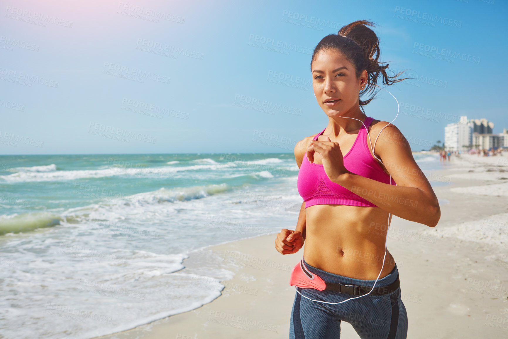 Buy stock photo Shot of an attractive young woman working out on the beach