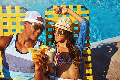 Buy stock photo High angle shot of an affectionate young couple enjoying a few drinks poolside