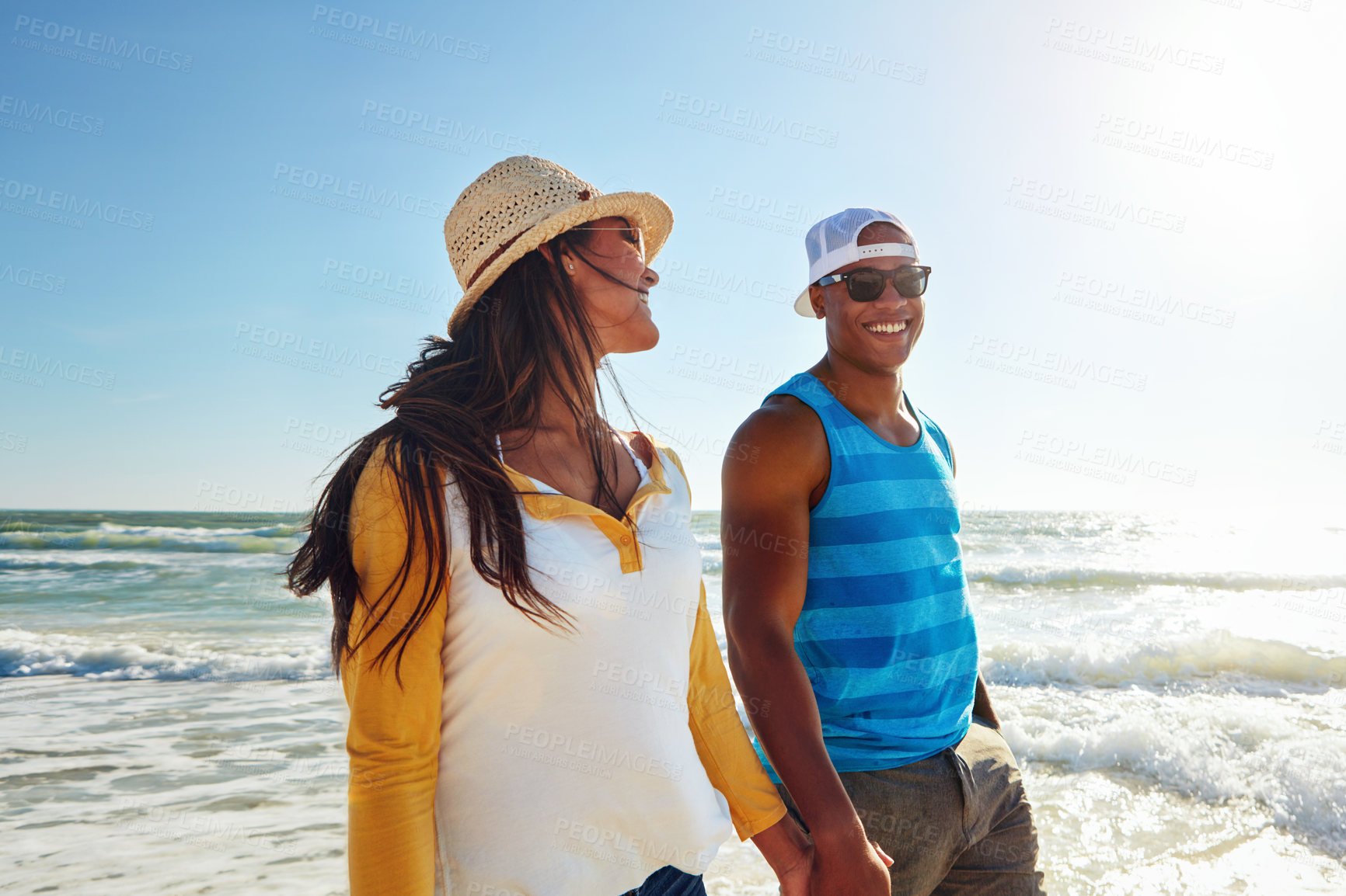 Buy stock photo Couple, happy and walking at beach with sunglasses, sun and relax for vacation by ocean in summer. Man, woman and smile on sand in Bali with blue sky, sun and partner on date for holiday or love