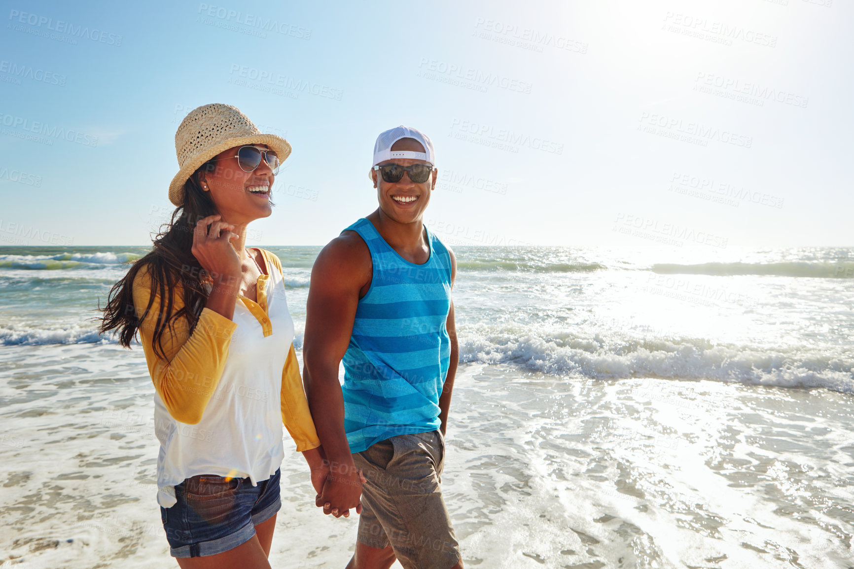 Buy stock photo Couple, happy and walking at beach with sunglasses, sun and relax for vacation by ocean in summer. Man, woman and smile on sand in Greece with blue sky, water and partner on date for holiday or love