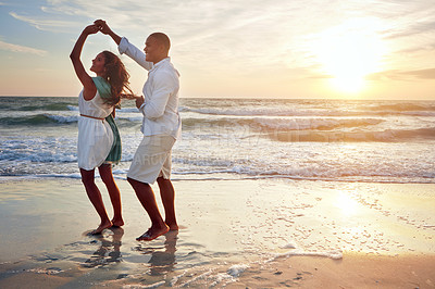 Buy stock photo Shot of a romantic couple dancing on the beach at sunset
