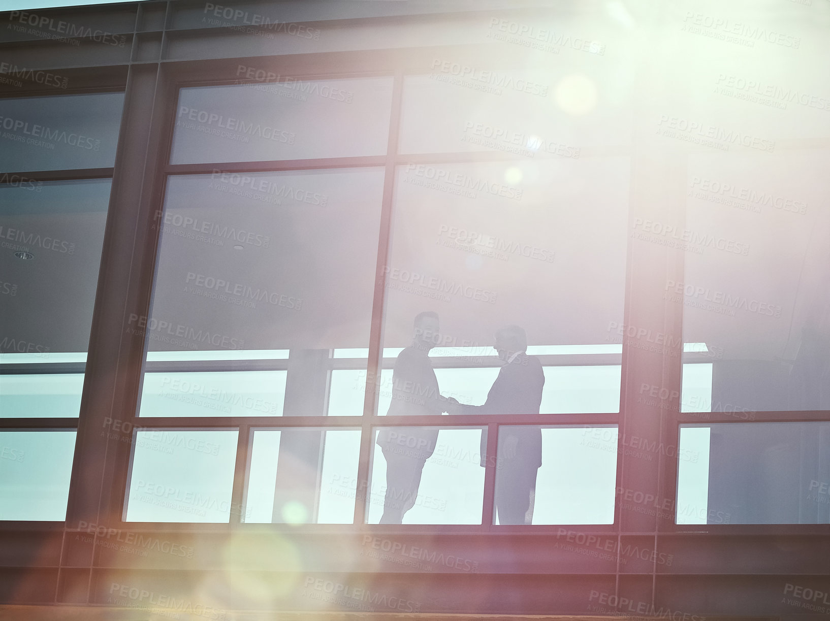 Buy stock photo Low angle shot of two businessman shaking hands in an office corridor