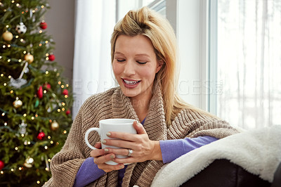 Buy stock photo Shot of a young woman relaxing at home with a cup of coffee