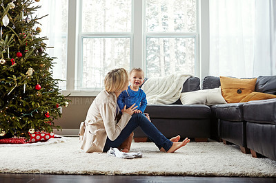 Buy stock photo Home, festive and mom with toddler in Christmas, living room and playful with son, love and care in apartment. House, mother and child in lounge, tree and fun together, happiness and wellness for boy