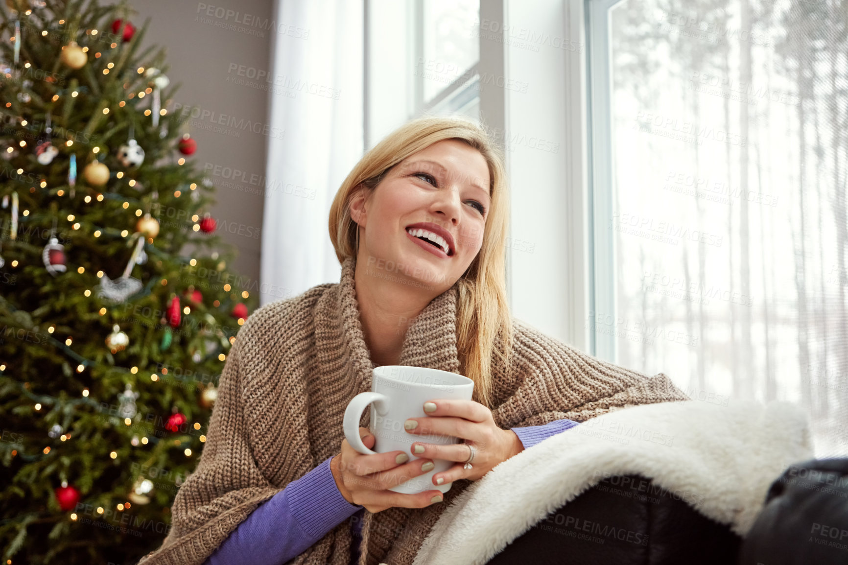 Buy stock photo Shot of a young woman relaxing at home with a cup of coffee