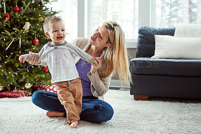 Buy stock photo Mother, baby and happy while on floor in living room, holding hands for love and christmas holiday. Smile, motherhood and toddler with woman together, hug and play by sitting for relationship at home