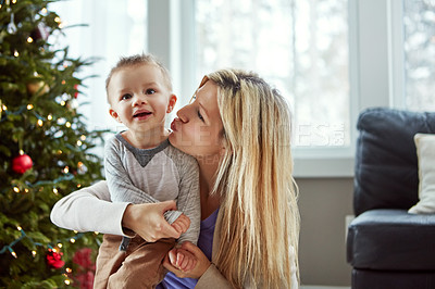 Buy stock photo Love, child and woman kiss for christmas, tree and laugh for bonding celebration together. Smile, trust for baby and family sit on floor, motherhood happiness and festive hugs for toddler at home