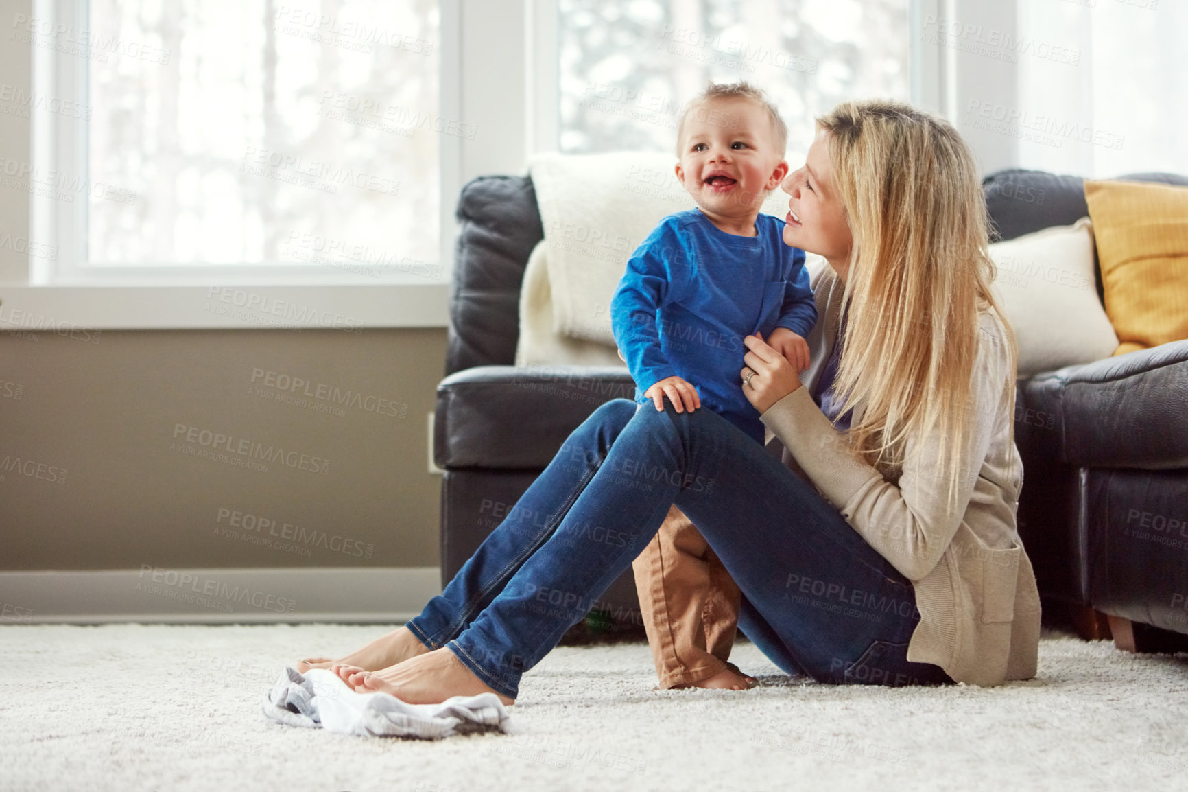 Buy stock photo Home, smile and hug of baby by mom, living room and playful with son, love and care in apartment. House, woman and toddler in lounge, mother and child together, happiness and wellness for boy